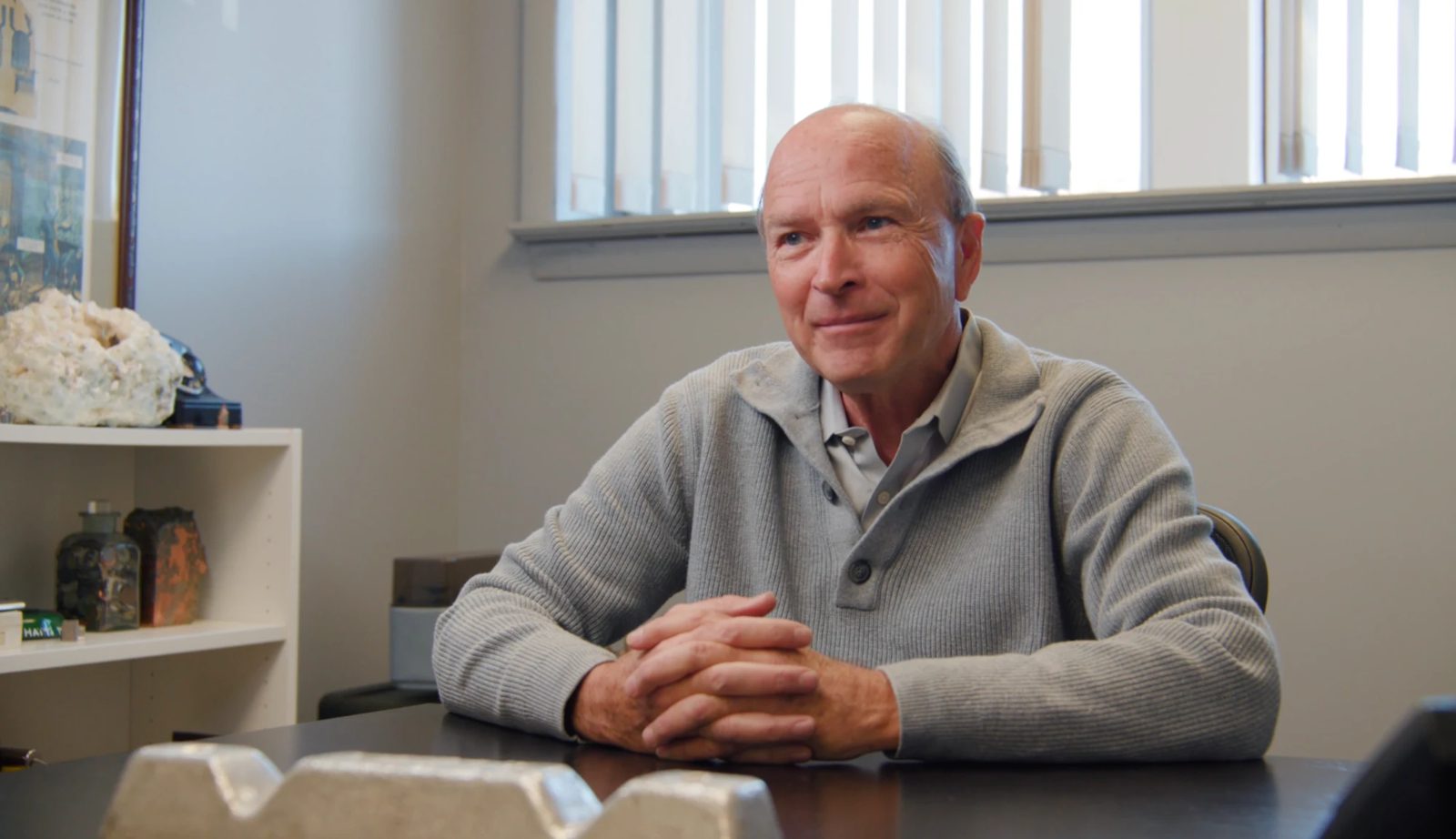 Tom Mele seated at a table in his office