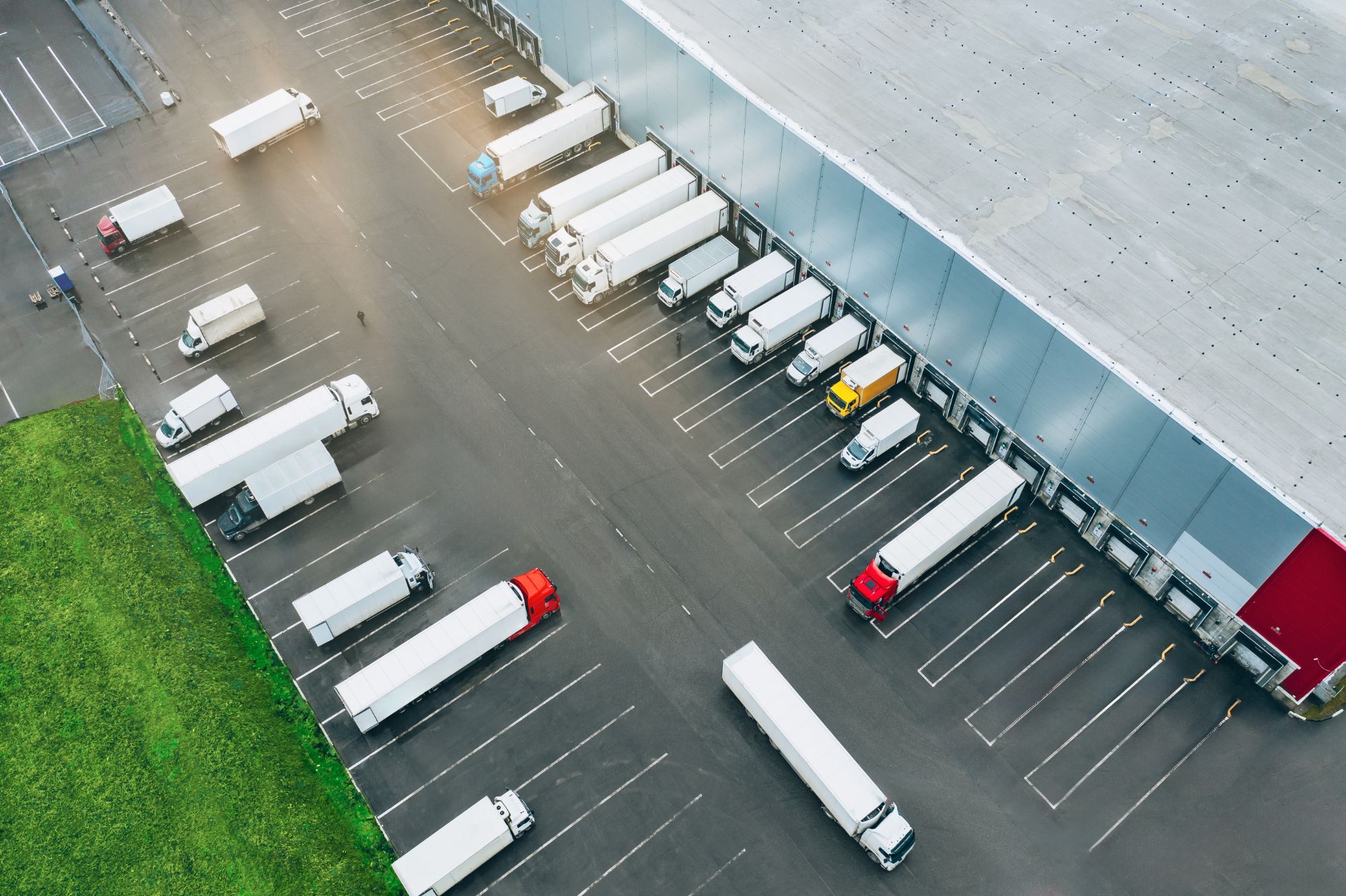 Aerial view of trucks parked at the loading bays of a large distribution facility