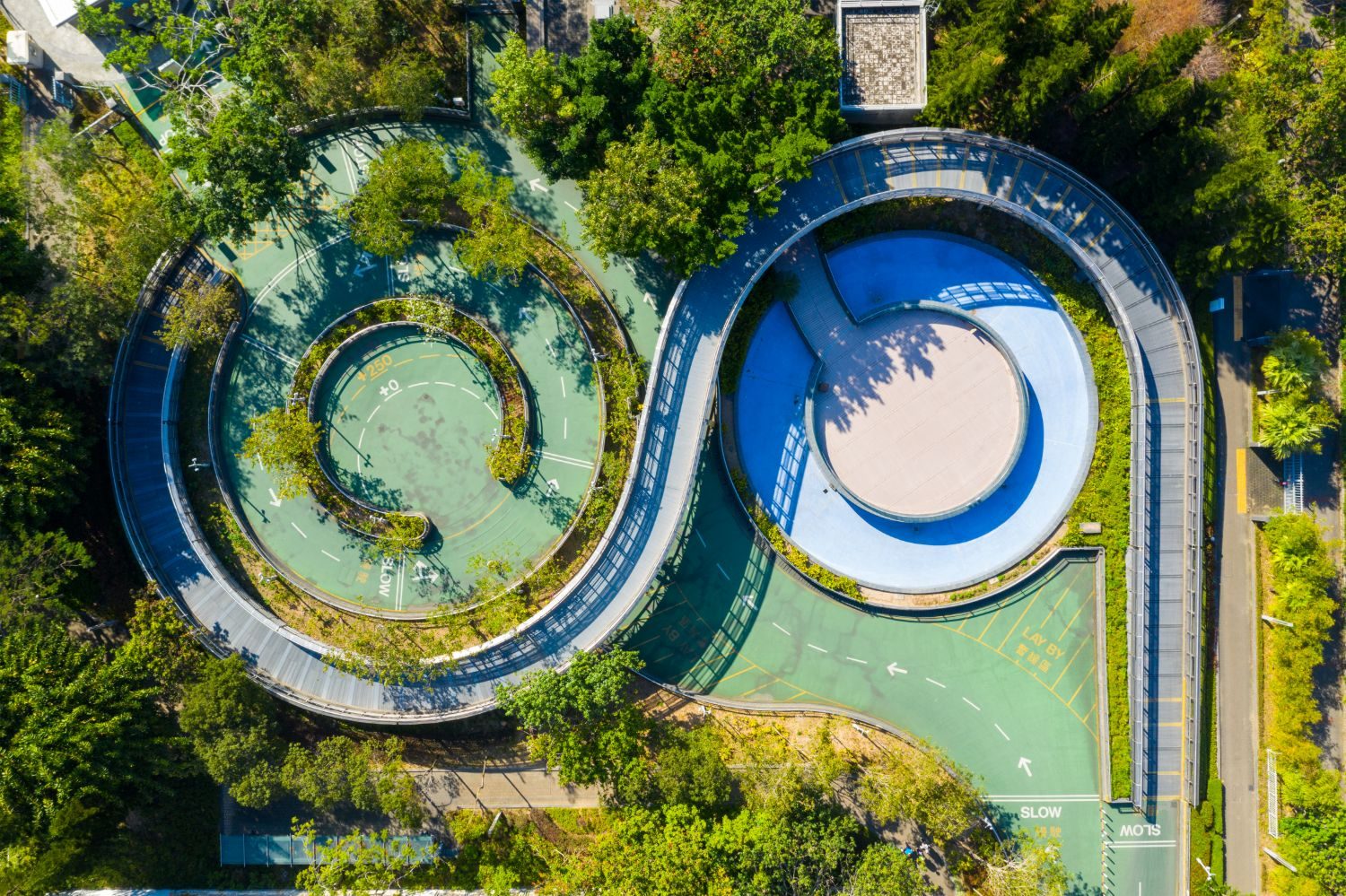 Aerial view of a looping, spiral walkway and road surrounded by trees